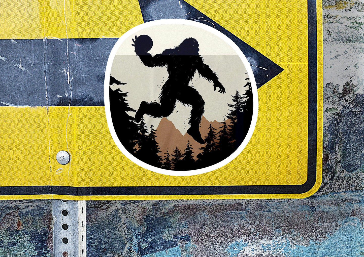 a street sign with a bigfoot sticker on it