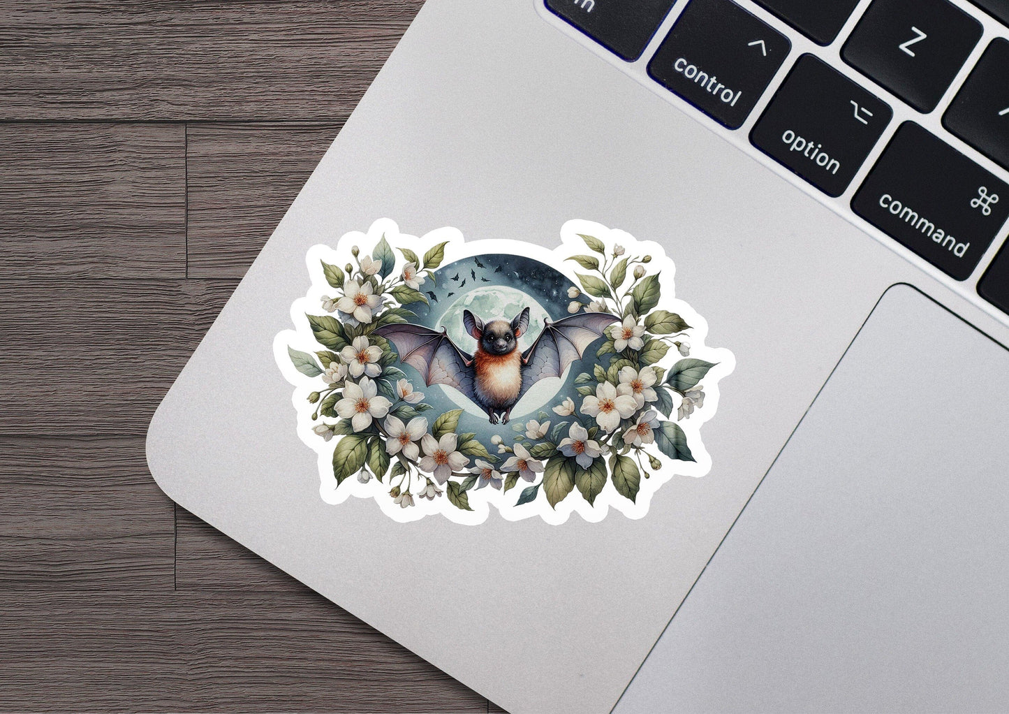 a laptop with a sticker of a bat on it
