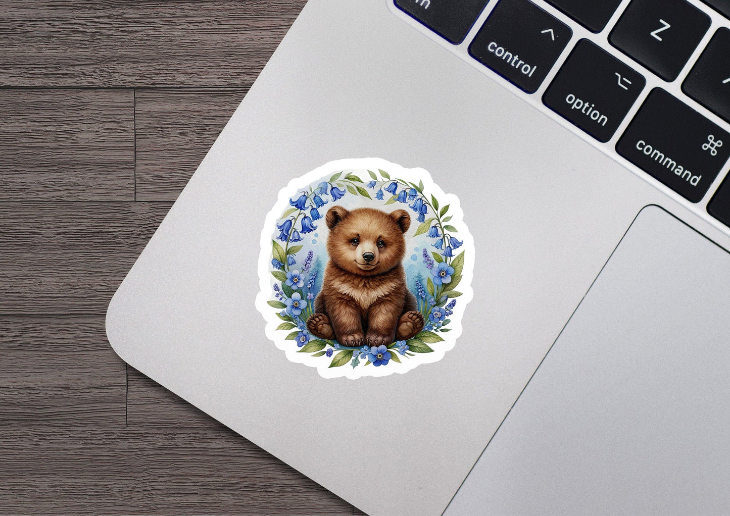 a sticker of a brown bear sitting on top of a laptop