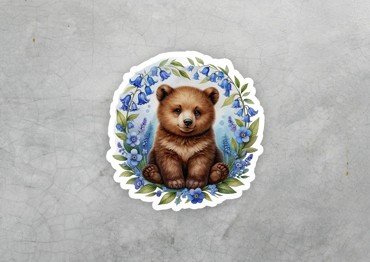 a sticker of a brown bear with blue flowers