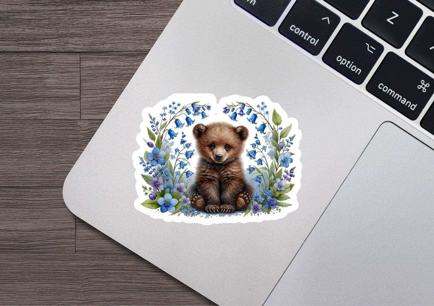 a sticker of a brown bear sitting on top of a laptop