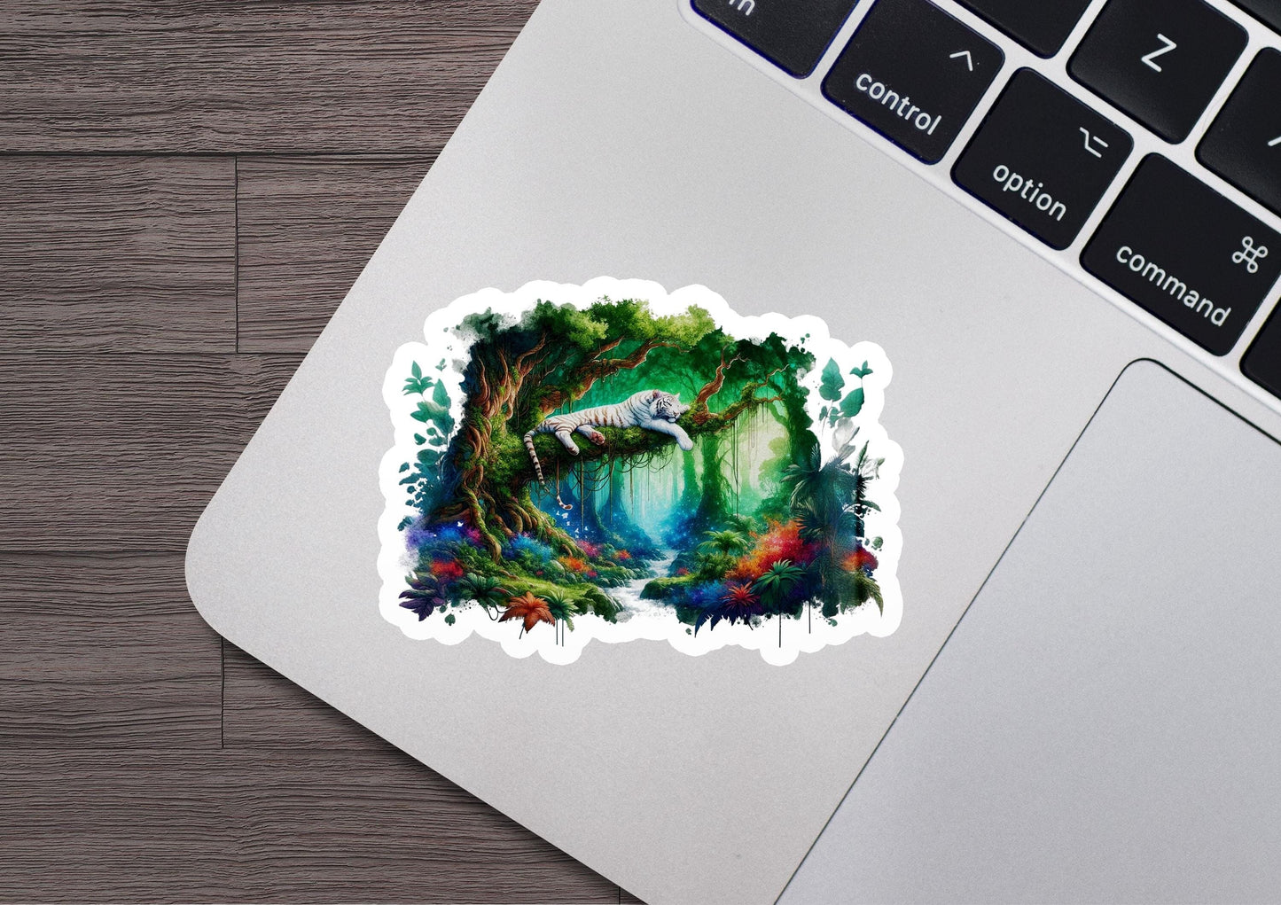 a laptop with a sticker of a forest scene
