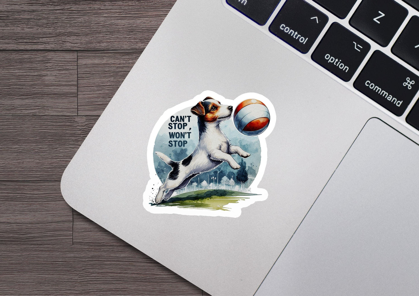 a sticker of a dog catching a ball on a laptop