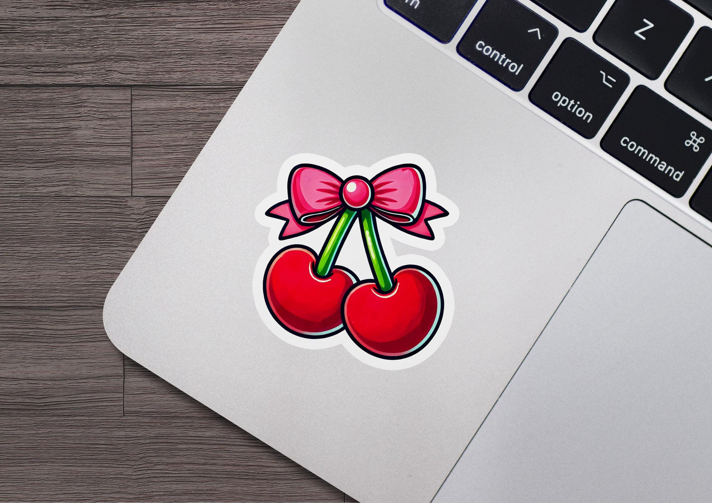 a sticker of two cherries with a bow