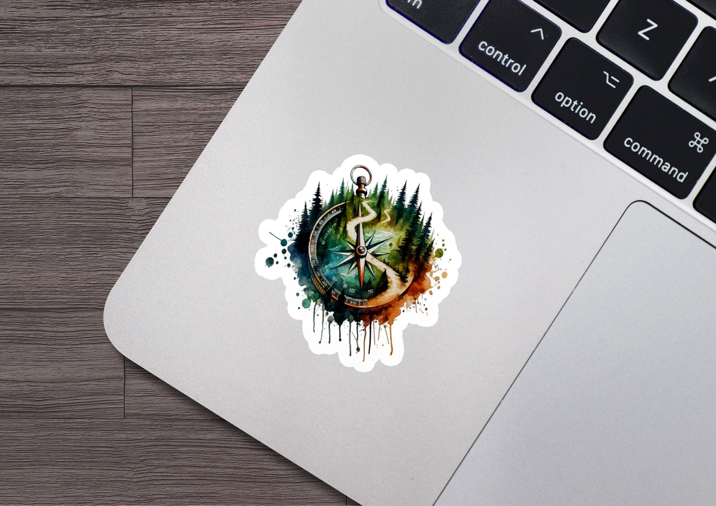 a laptop with a sticker of a tree and a compass on it