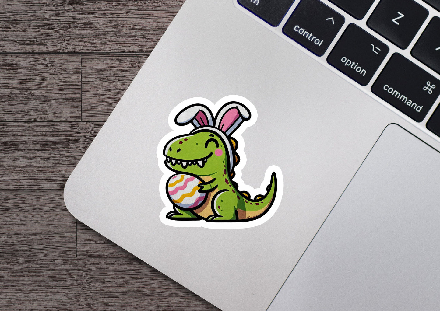 a laptop with a sticker of a dinosaur with an easter egg