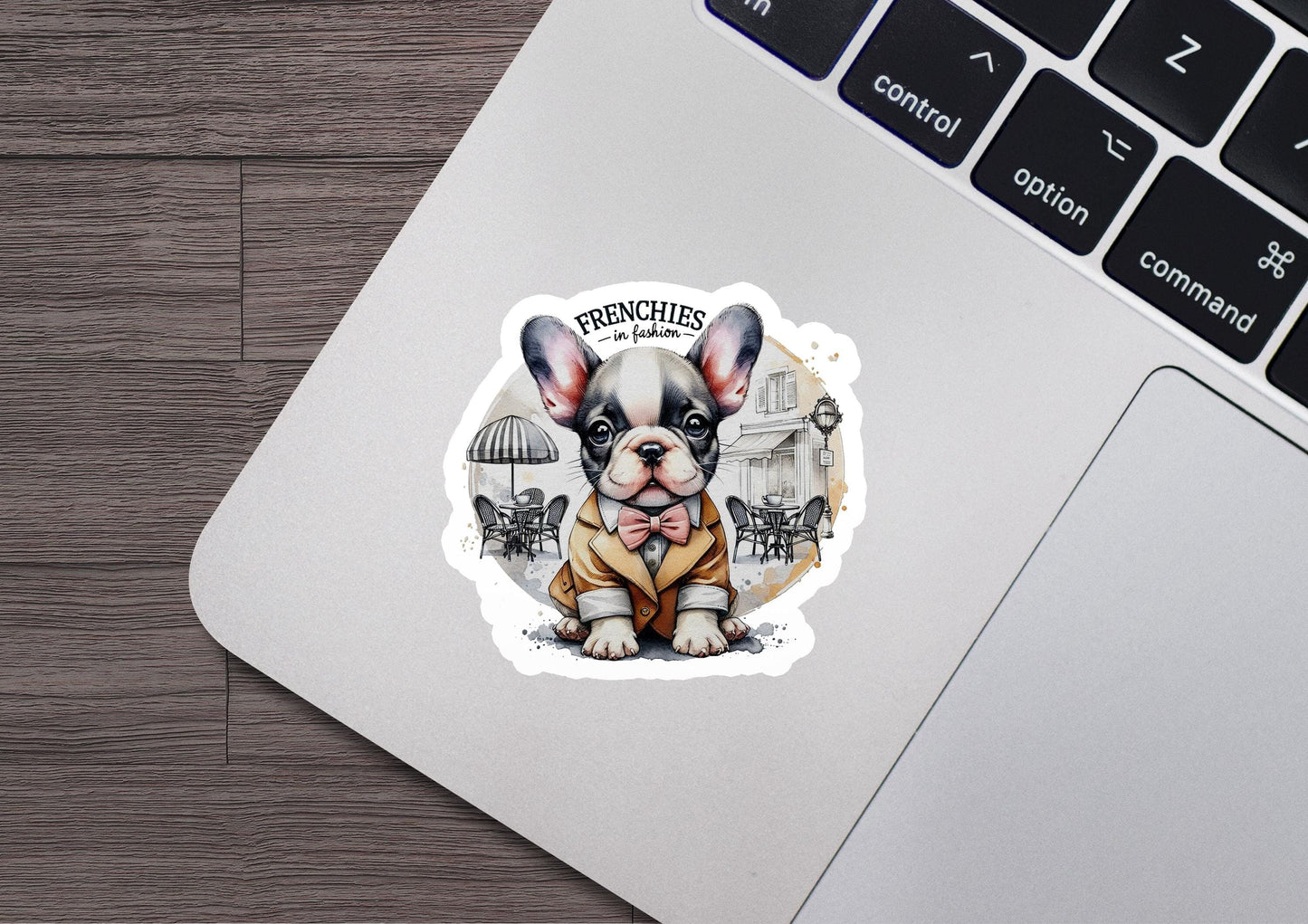 a sticker of a french bulldog sitting on top of a laptop