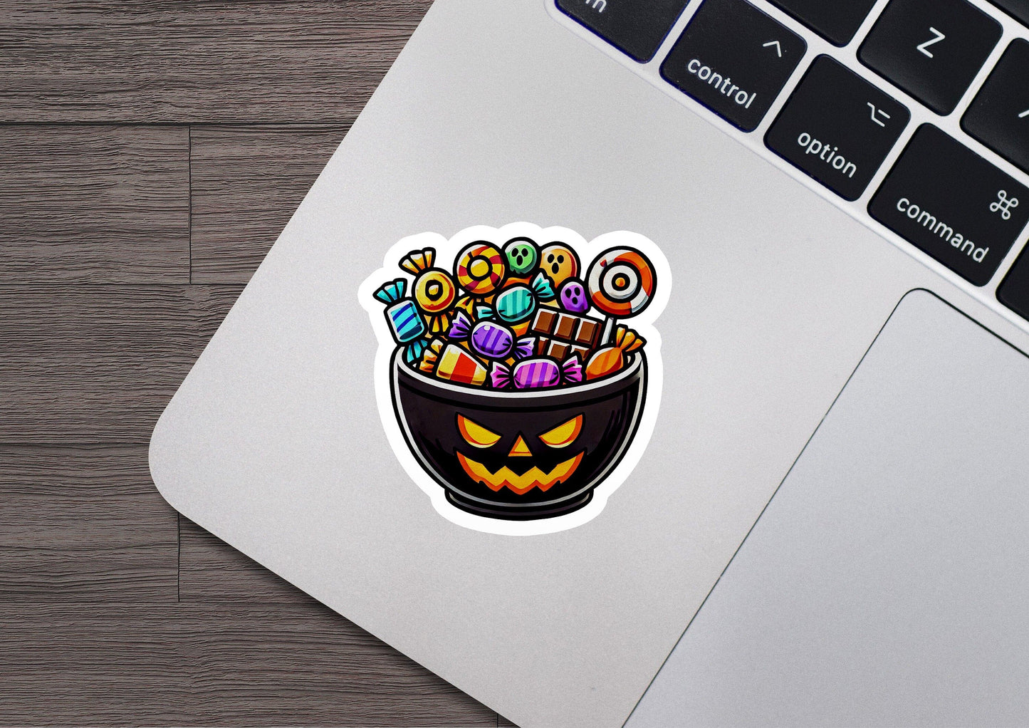 a laptop with a sticker of a halloween candy bowl