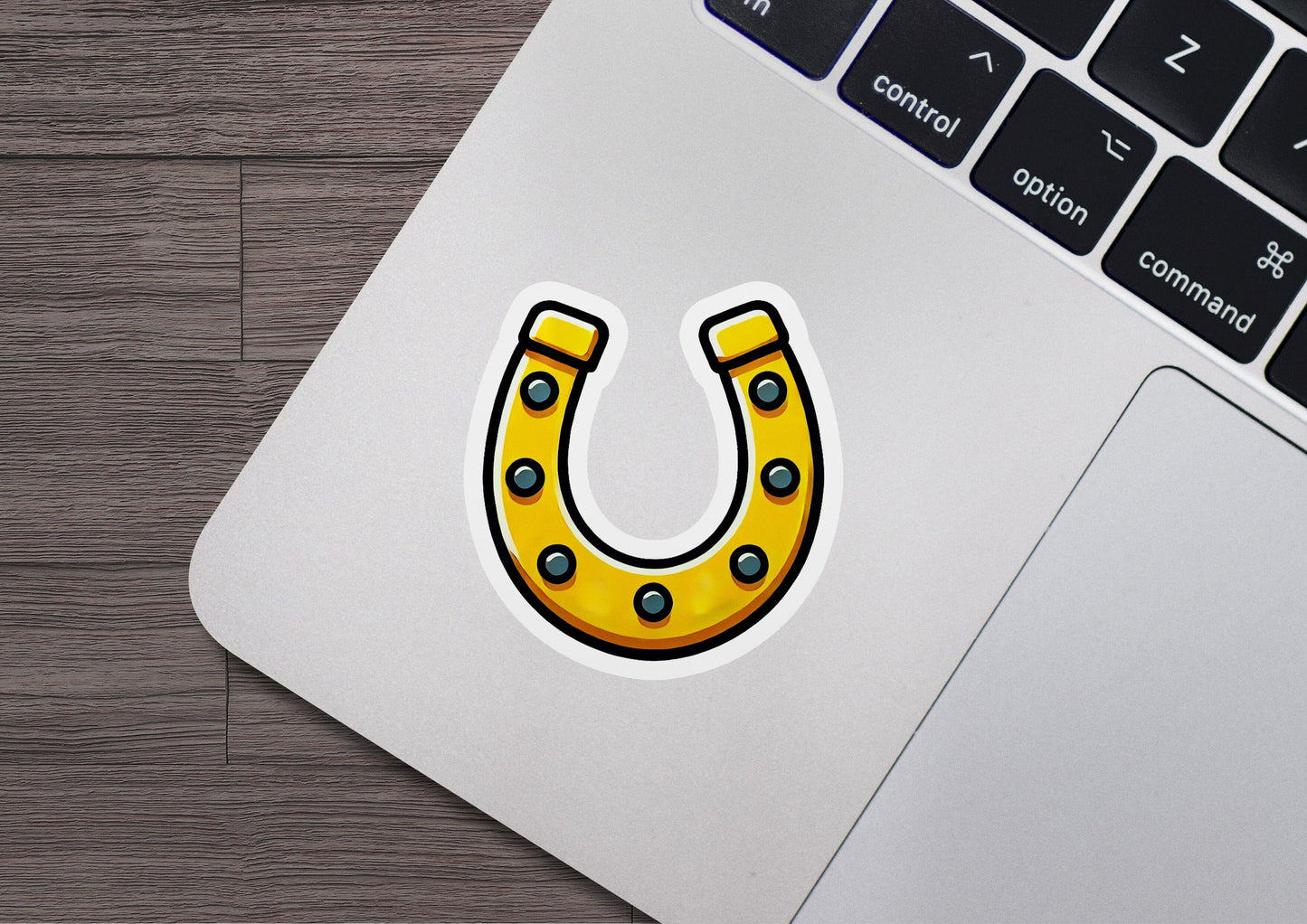 a laptop with a sticker of a yellow horseshoe
