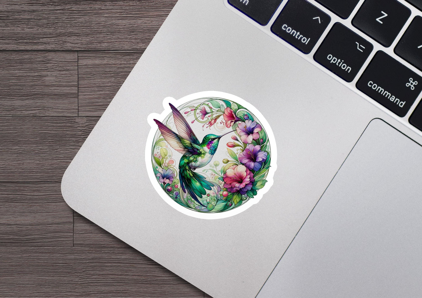 a sticker of a hummingbird and flowers on a laptop