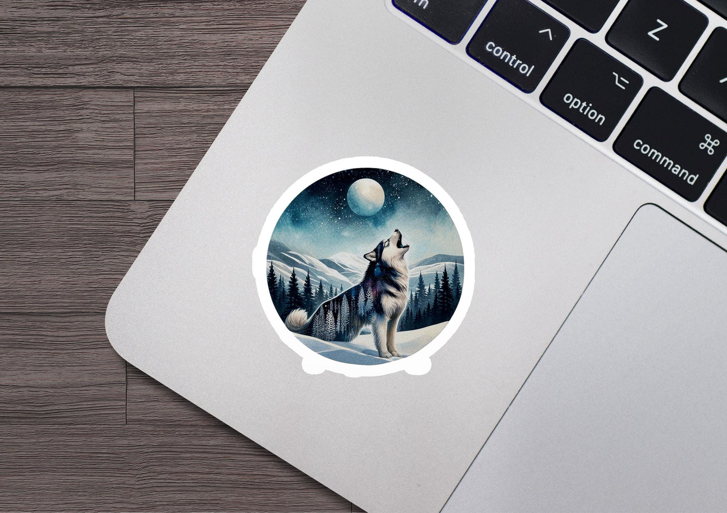 a wolf sticker sitting on top of a laptop computer