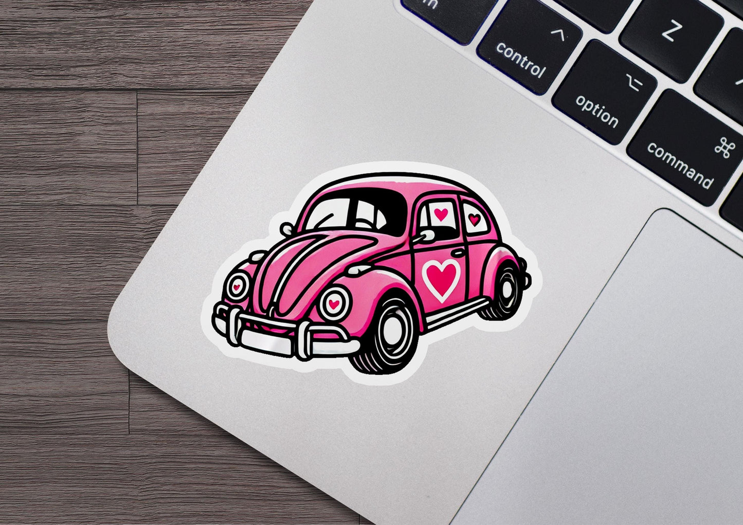 a pink car sticker sitting on top of a laptop computer