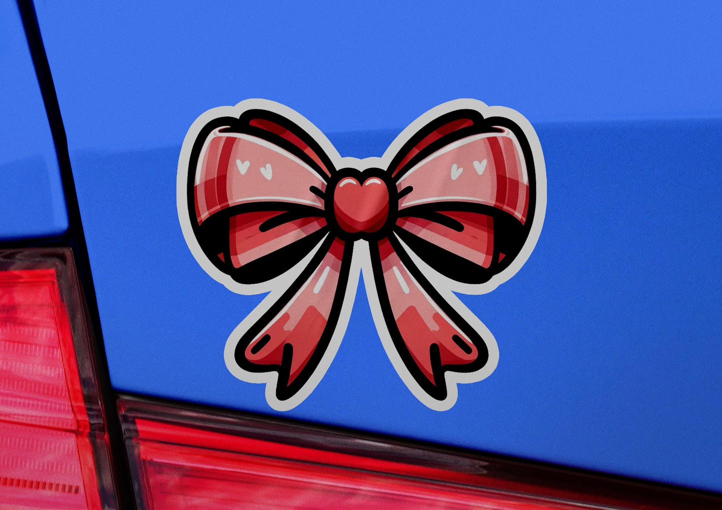 a red bow sticker on the back of a blue car