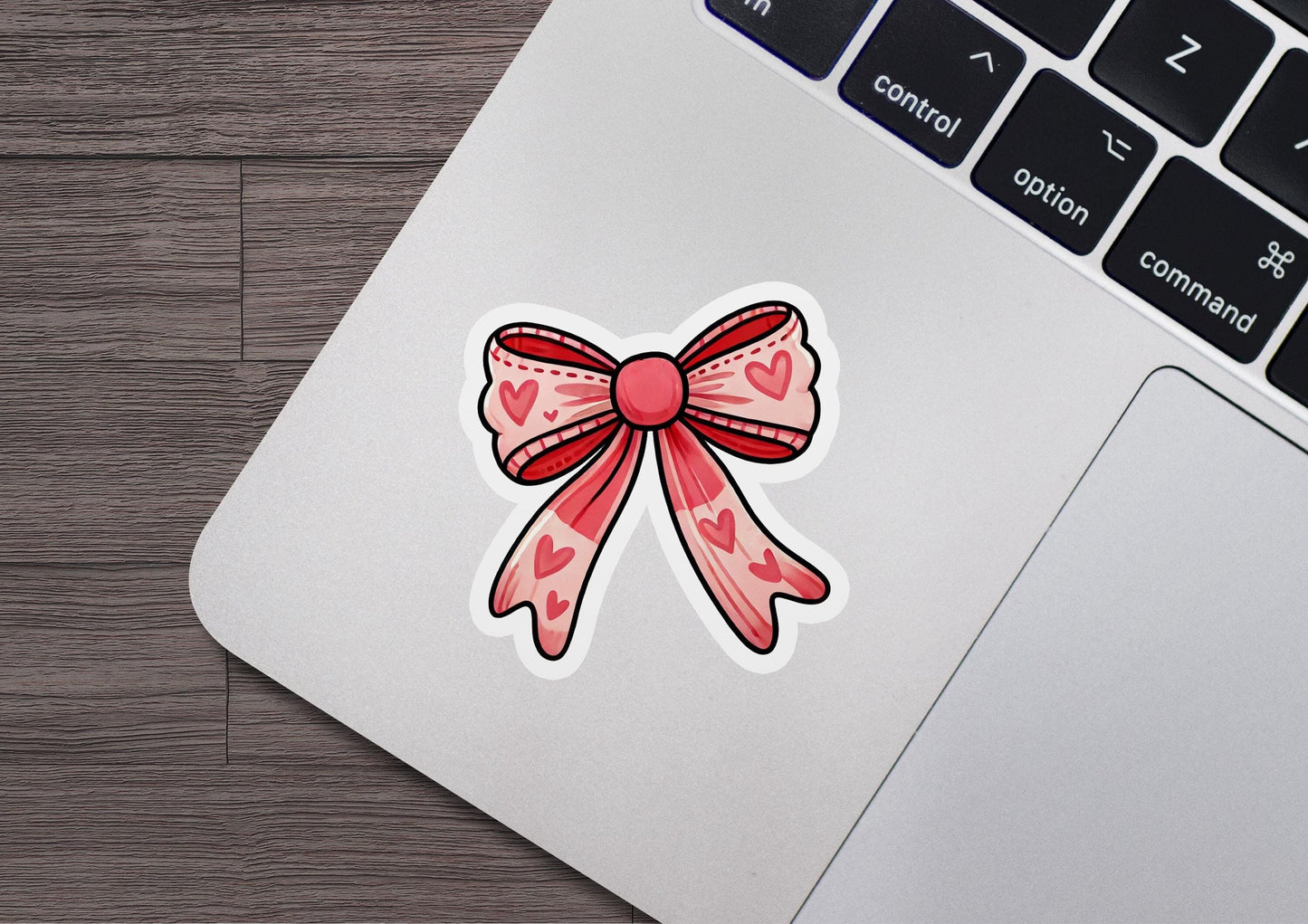 a laptop with a sticker of a bow on it
