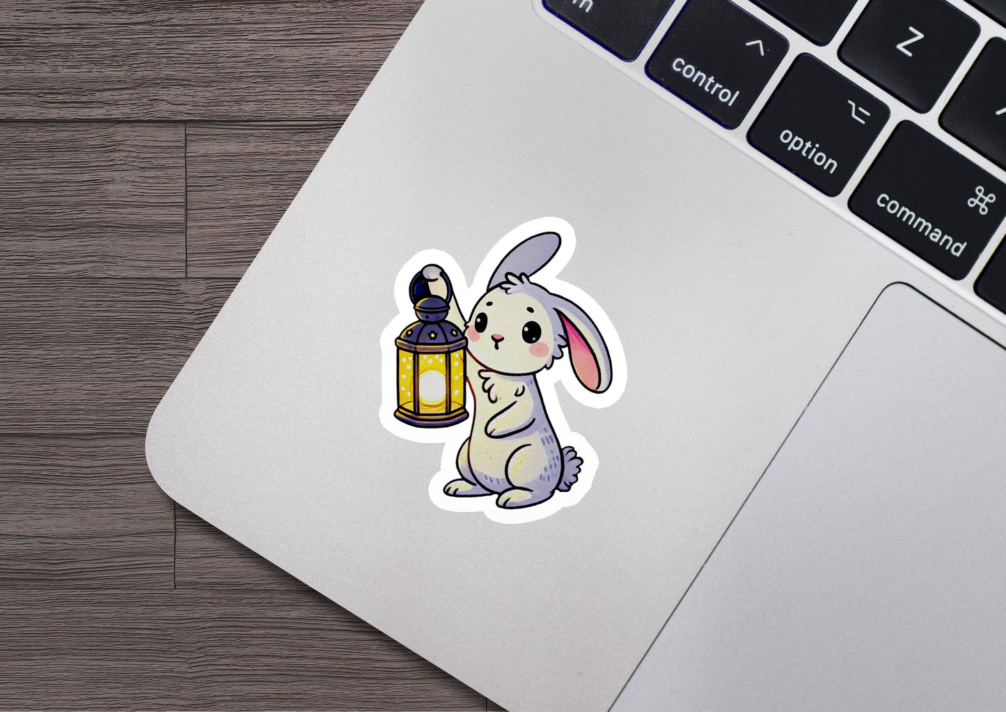 a laptop with a sticker of a rabbit holding a lantern