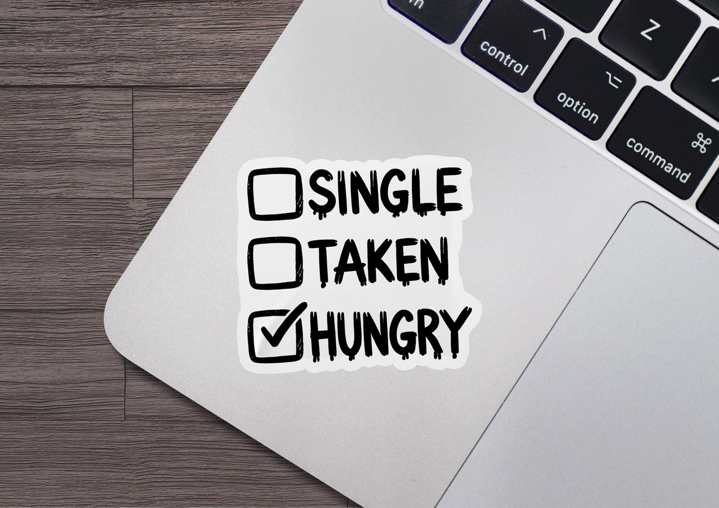 a sticker that says single taken hungry on a laptop