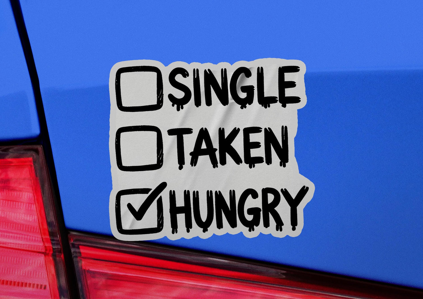 a sticker on the back of a car that says single taken hungry