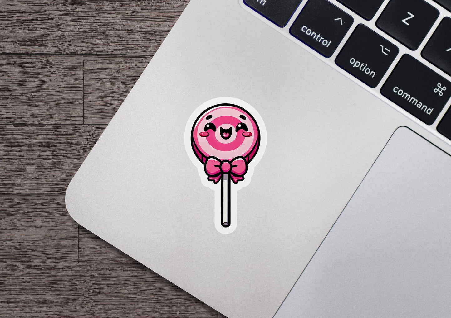 a sticker of a pink lollipop sitting on top of a laptop