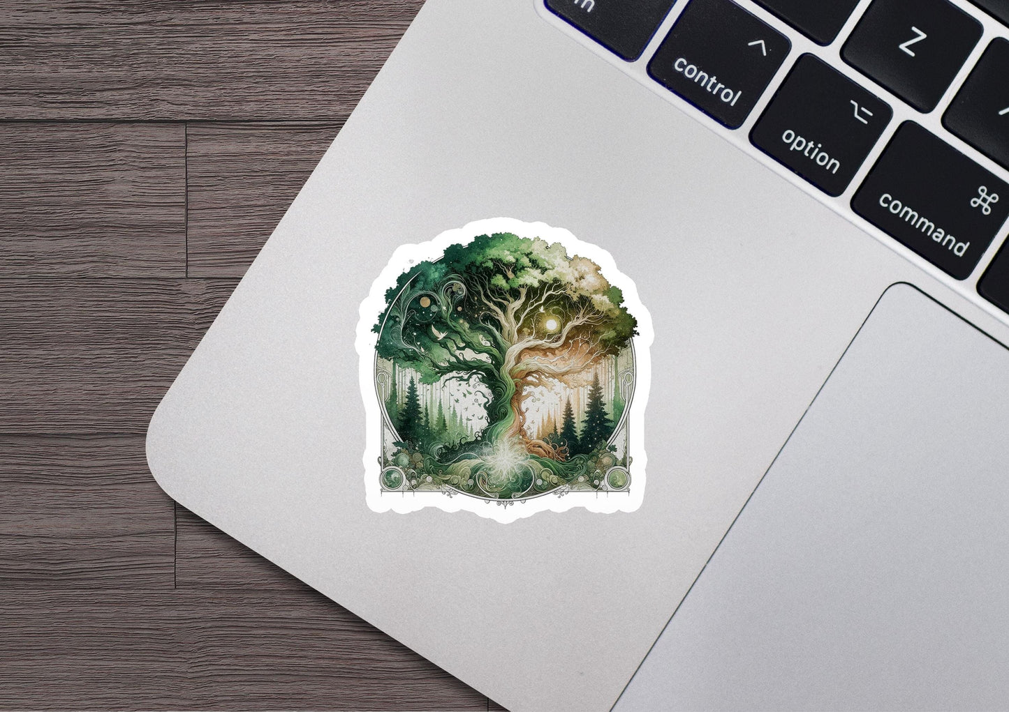 a laptop with a sticker of a forest scene