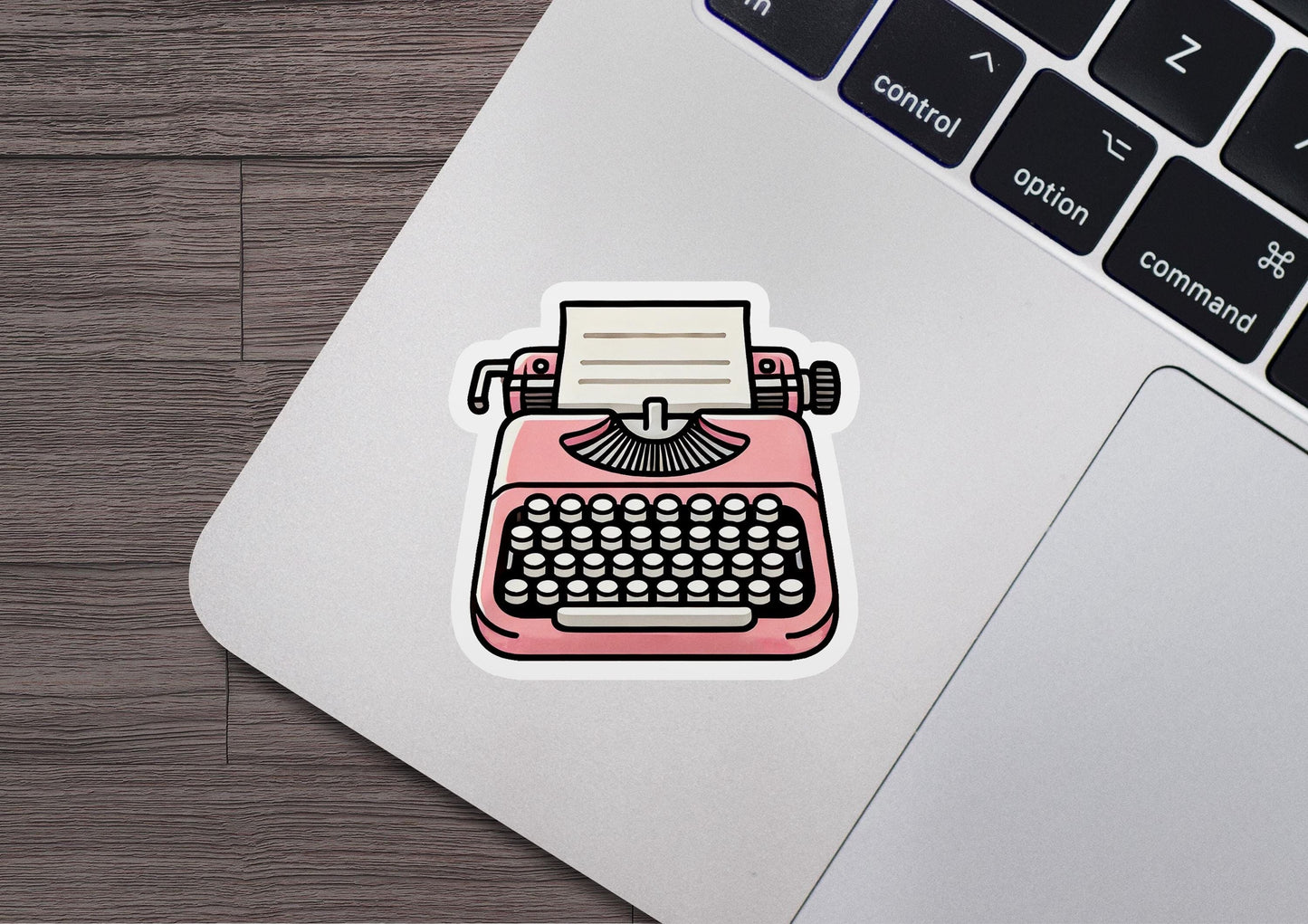 a laptop with a sticker of a pink typewriter