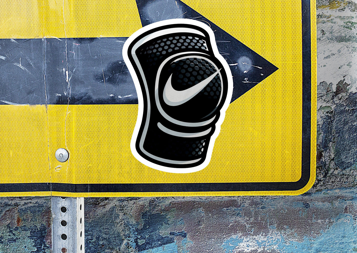 a yellow street sign with a black and white sticker on it