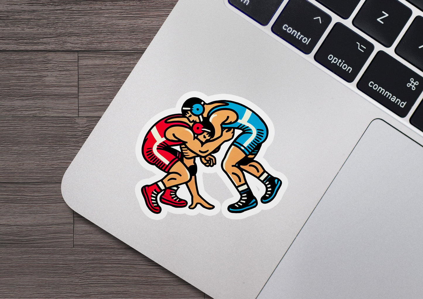 a sticker of two men wrestling on a laptop