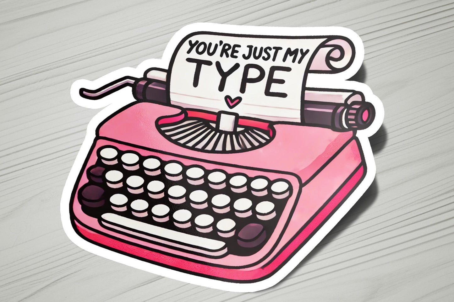 a pink sticker with a typewriter on it
