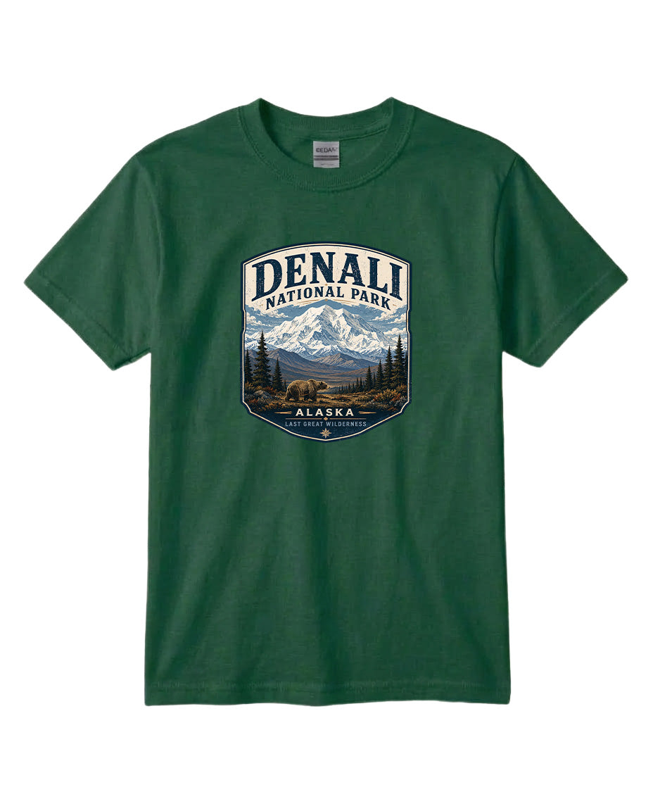 A green t-shirt with a graphic design featuring a mountain landscape and the text "DENALI NATIONAL PARK ALASKA LAST GREAT WILDERNESS".