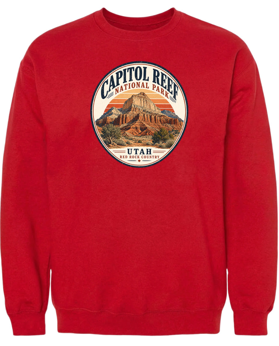 A red sweatshirt with a circular graphic design featuring a mountain and the text "CAPITOL REEF NATIONAL PARK UTAH ROCK COUNTRY".