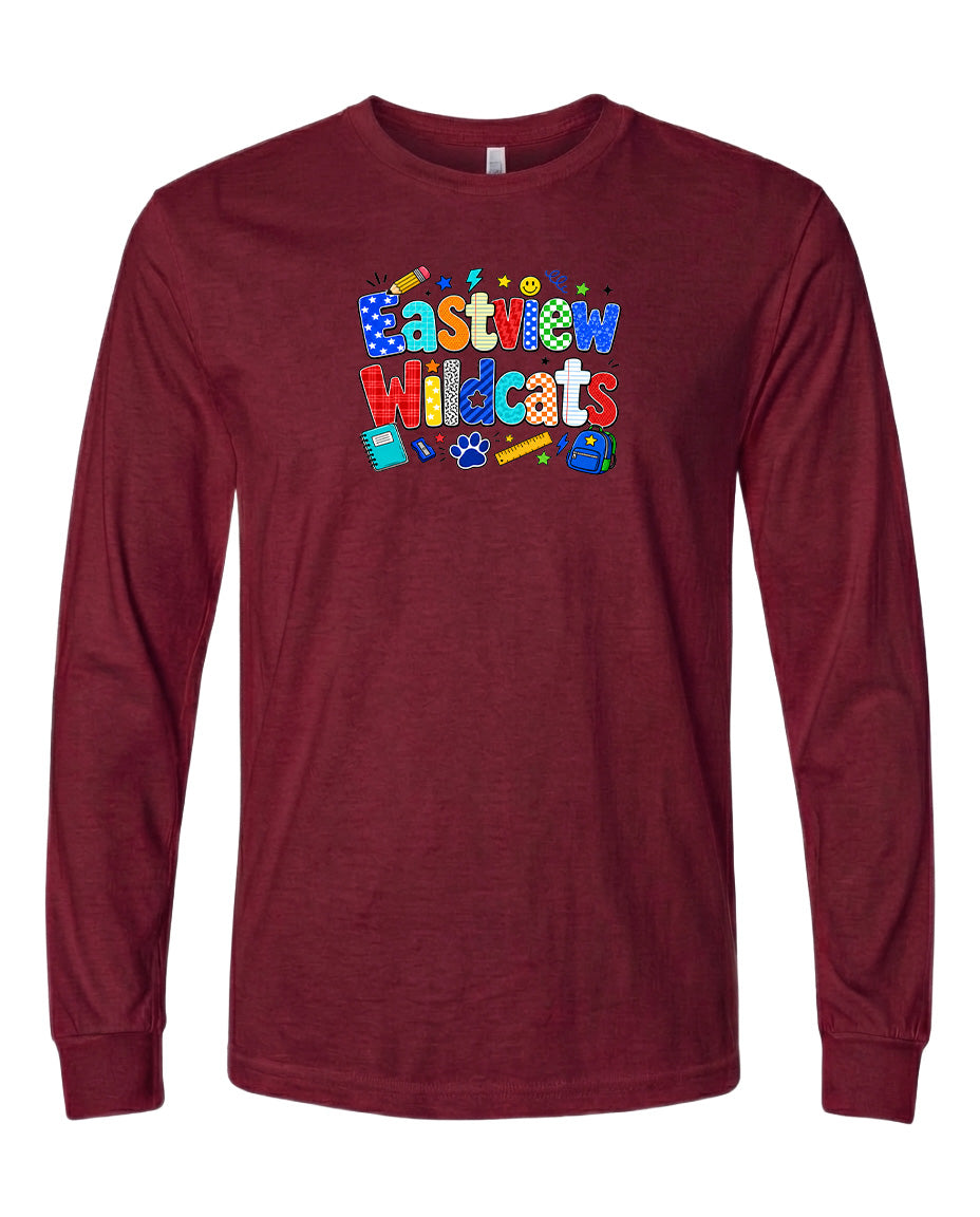 A burgundy long-sleeved t-shirt with a colorful graphic design featuring the text "Eastview Wildcats" and various school supplies such as pencils, books, and a backpack.