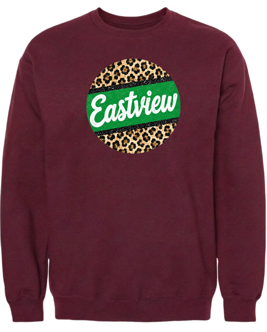 A burgundy-colored sweatshirt with a circular logo on the front. The logo features a green border and a leopard print design, with the word "Eastview" written in white cursive text.