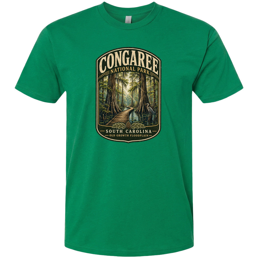A green t-shirt with a graphic design depicting a forest scene with a path leading through it, surrounded by trees and foliage.