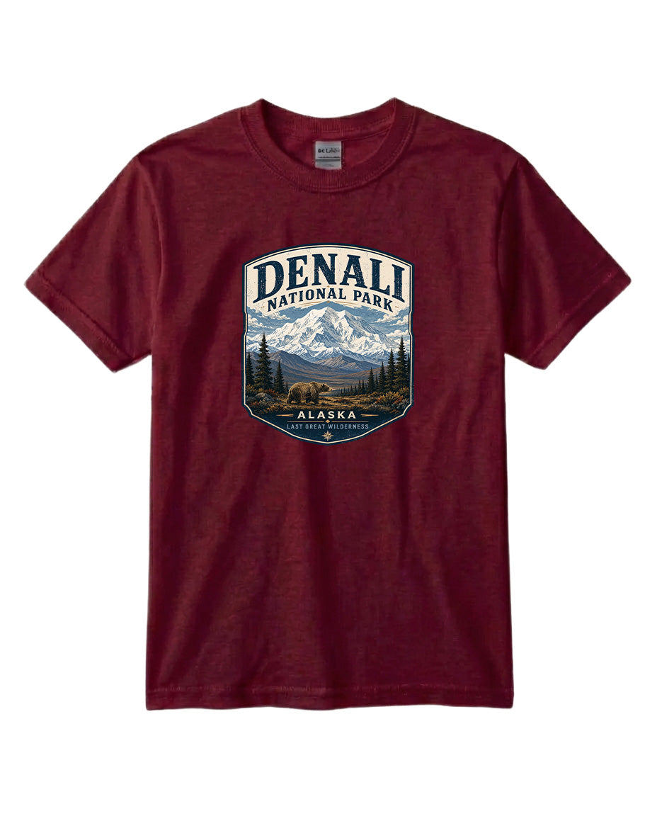 A burgundy-colored t-shirt with a graphic design depicting a mountain landscape and bears, along with the text "DENALI NATIONAL PARK ALASKA LAST GREAT WILDERNESS".