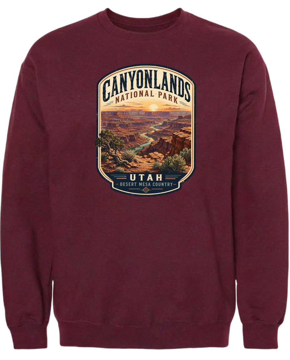 A burgundy-colored sweatshirt with a graphic design depicting the scenic landscape of Canyonlands National Park in Utah.