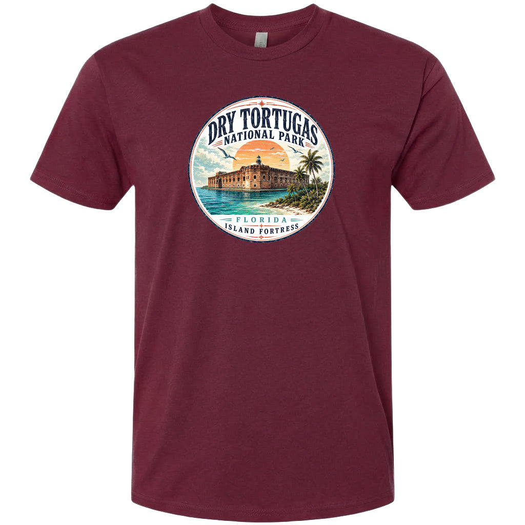 A t-shirt with a circular design featuring a beach scene and a building, likely representing Dry Tortugas National Park in Florida.