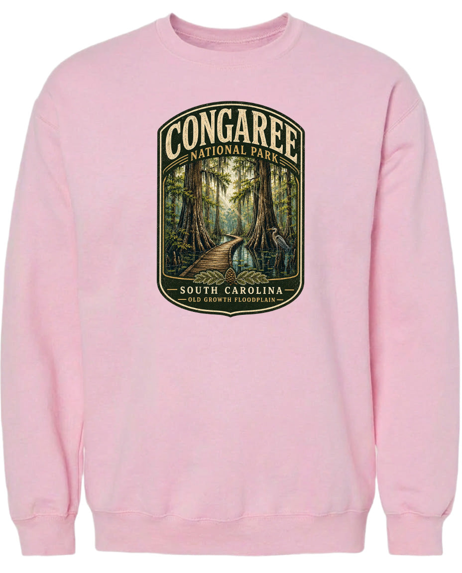 A pink sweatshirt with a graphic design depicting a forest scene with a path leading through it.