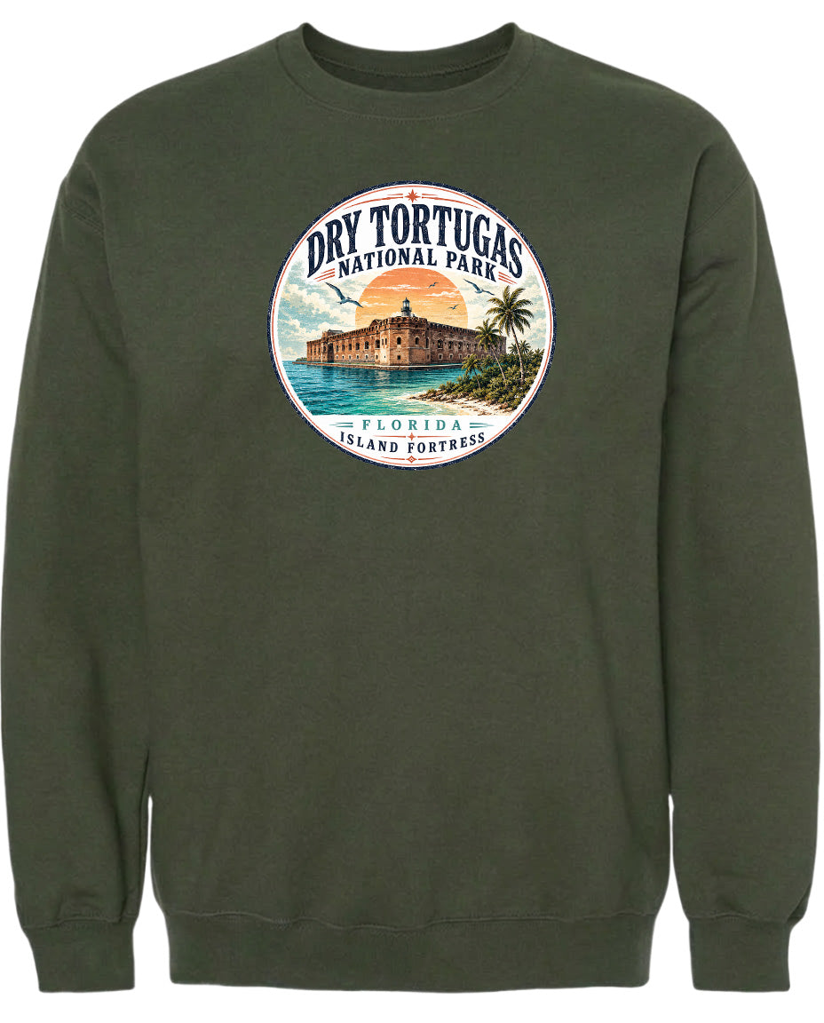 A circular graphic on a dark green sweatshirt depicting a tropical island with a building and palm trees, surrounded by a sunset and ocean.