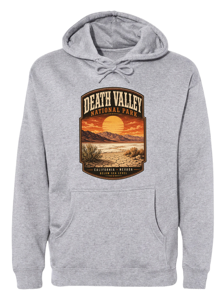 A gray hoodie with a graphic design depicting Death Valley National Park, including a sunset landscape and mountains.