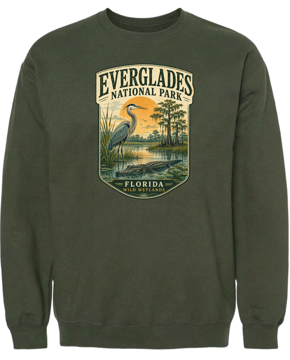 A green sweatshirt with a graphic design depicting a heron and a landscape with trees and water.
