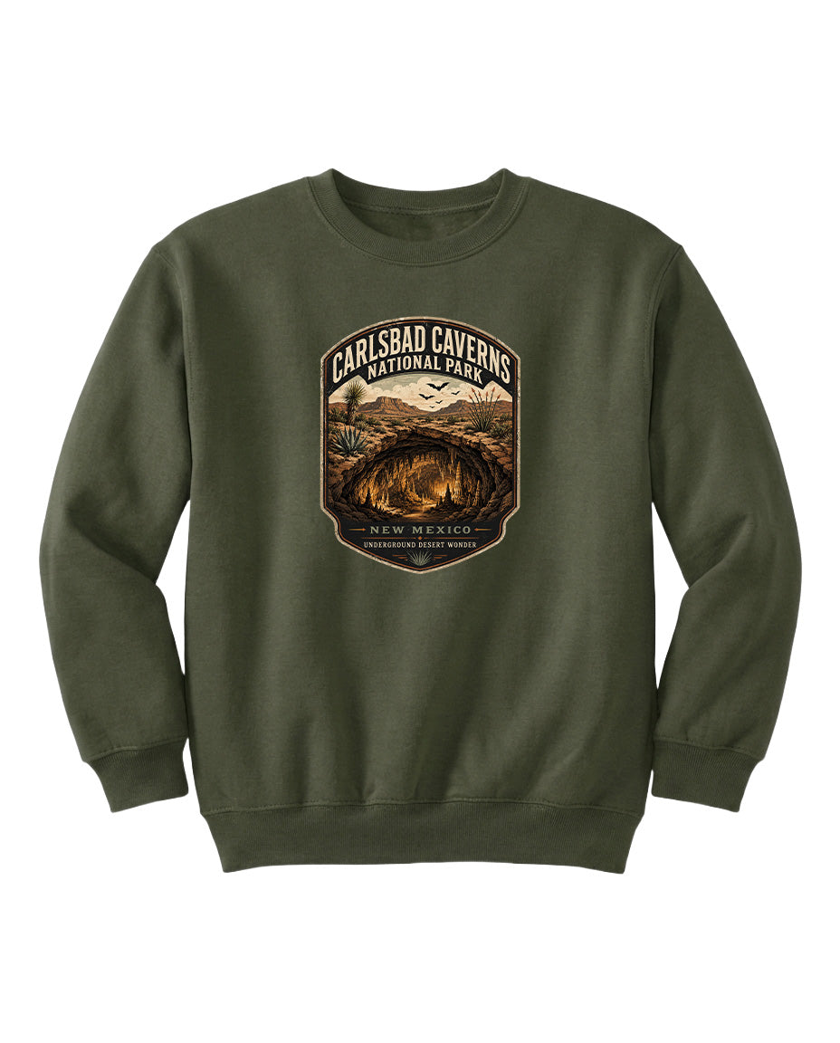 A green sweatshirt with a graphic design featuring a desert landscape and the text "CARLSBAD CAVENS NATIONAL PARK NEW MEXICO UNDERGROUND WONDER".