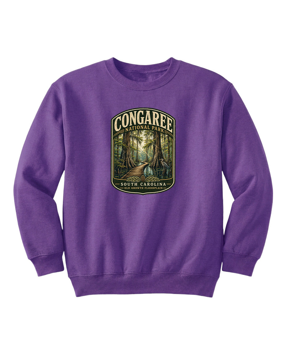 A purple sweatshirt with a graphic design depicting a forest path leading through Congaree National Park in South Carolina.