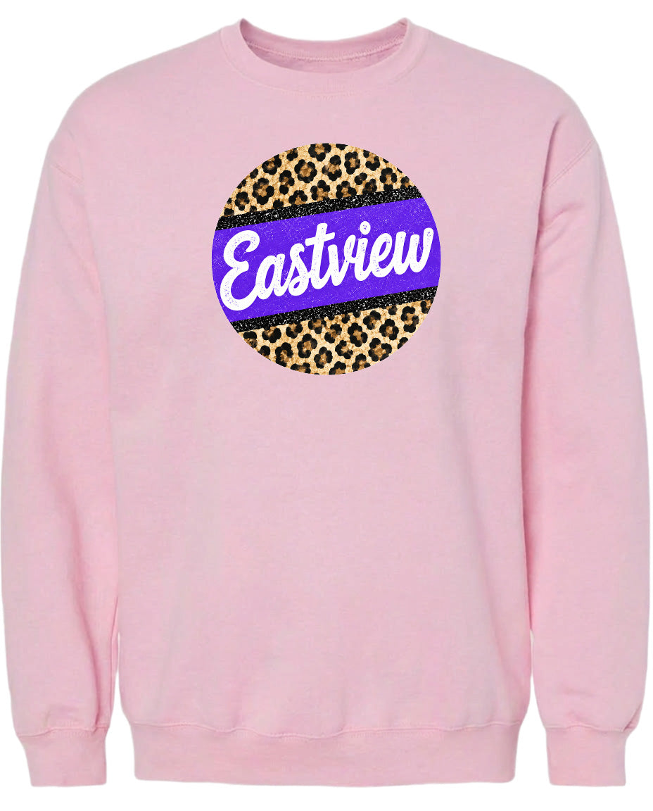 A pink sweatshirt with a large circular logo on the front. The logo features a leopard print design with a purple border.