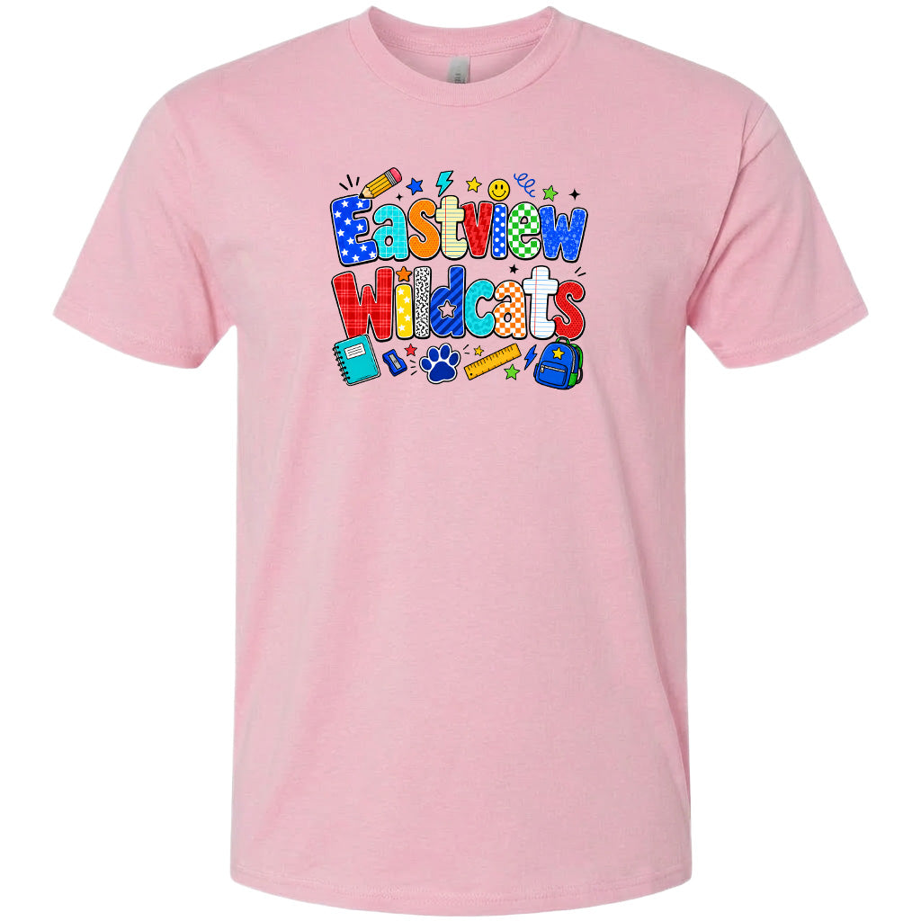 A pink t-shirt with a colorful graphic design featuring the text "Eastview Wildcats" and various school-related icons such as a backpack, pencil, and book.