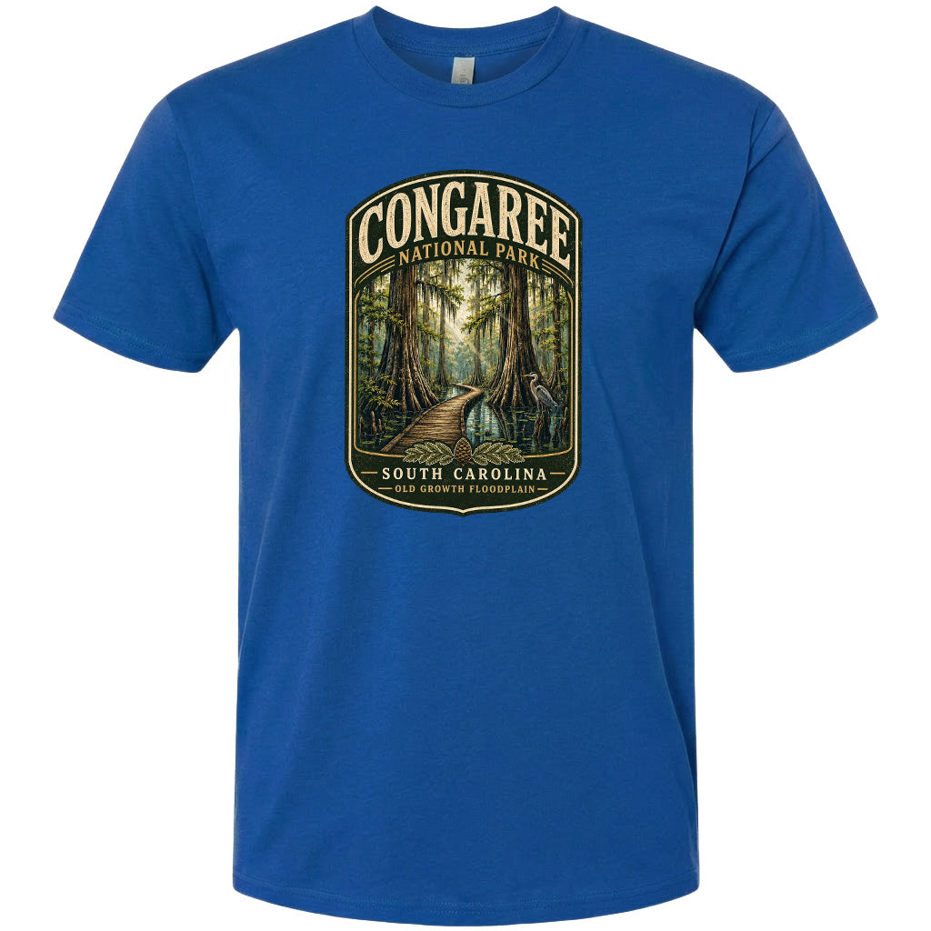 A blue t-shirt with a graphic design depicting a forest scene with a path leading through it, surrounded by trees and foliage.