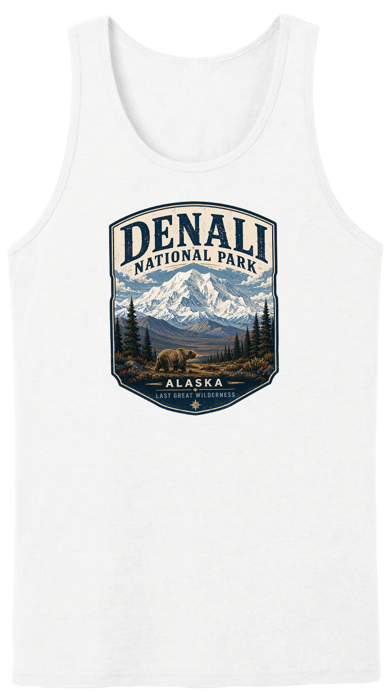 A white tank top with a graphic design featuring a mountain landscape with a bear in the foreground, surrounded by pine trees and the text "DENALI NATIONAL PARK ALASKA LAST GREAT WILDERNESS".