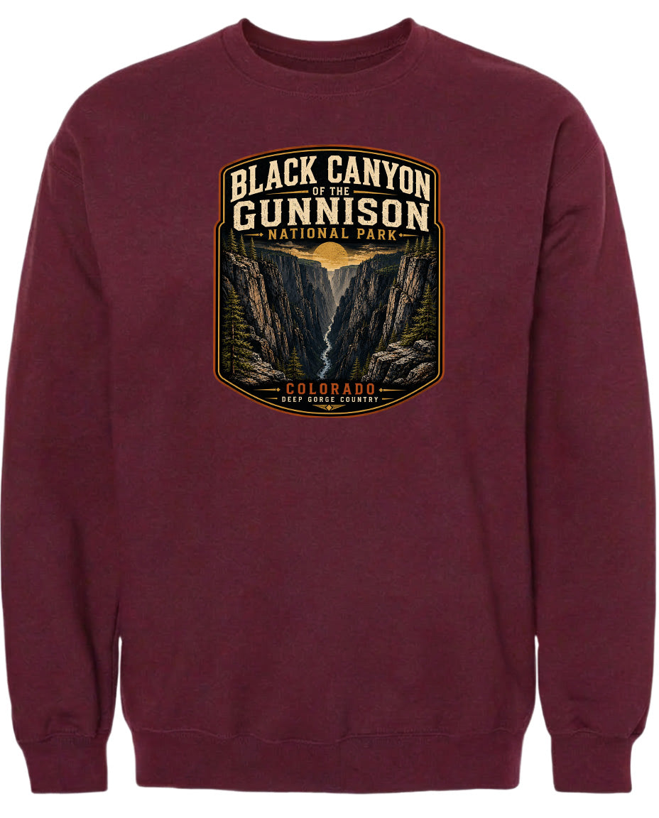 A burgundy-colored sweatshirt with a graphic design depicting the Black Canyon of the Gunnison National Park in Colorado.