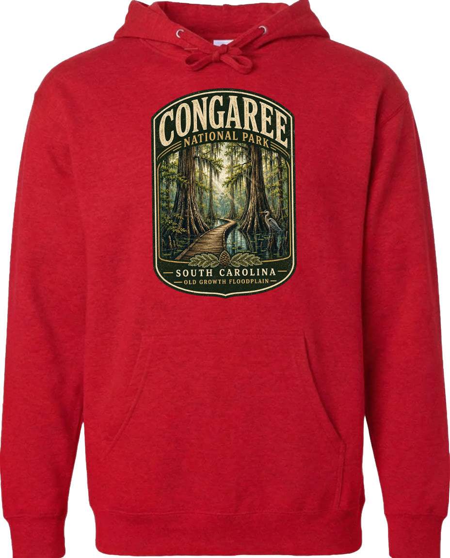 A red hoodie with a graphic design depicting a forest path leading through Congaree National Park in South Carolina.