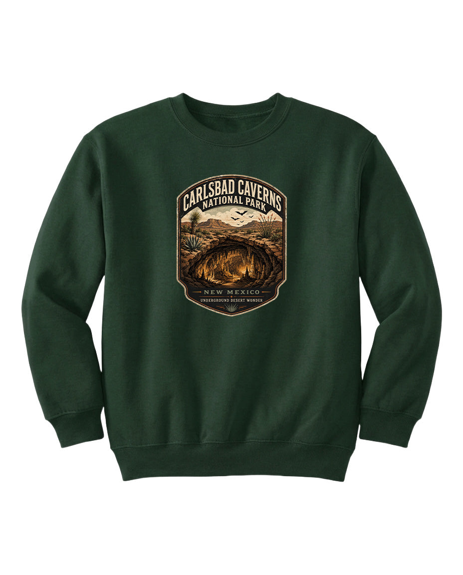 A green sweatshirt with a graphic design featuring a desert landscape and the text "CARLSBAD CAVERSNATIONAL PARK NEW MEXICO UNDERGROUND WONDER".
