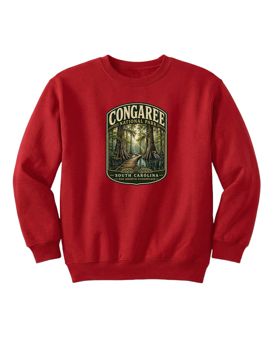 A red sweatshirt with a graphic design depicting a forest scene, featuring the text "CONGAREE NATIONAL PARK SOUTH CAROLINA" prominently displayed.