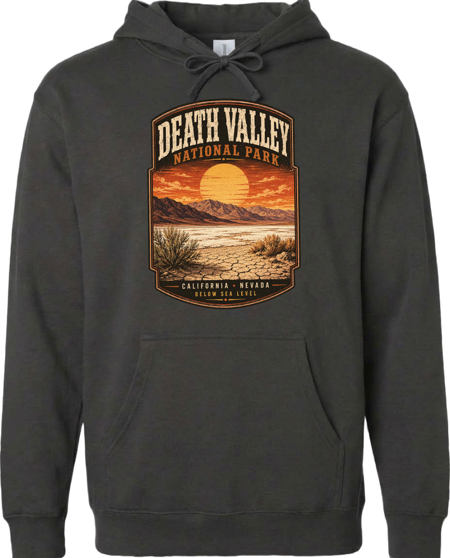 A hoodie with a graphic design depicting a desert landscape with mountains, a sunset, and a cactus plant.